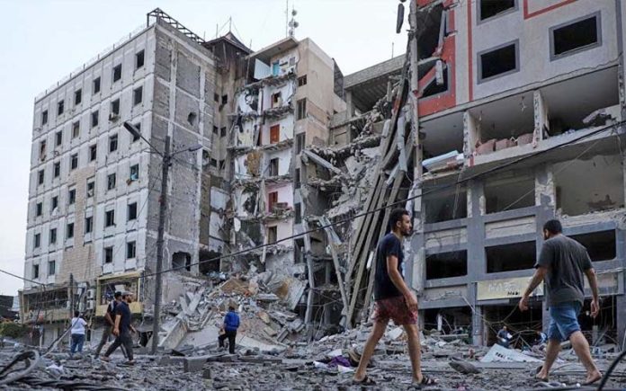 10月8日，巴勒斯坦人在迦薩查看以色列空襲後的建築廢墟。（新華社圖片）