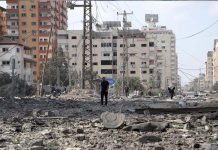 以巴正面戰場對決 哈瑪斯簡陋武器如何取勝? 10月10日,在加薩走廊人們走過被以色列空襲炸毀的建築廢墟。(圖自新華社)