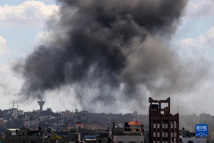 加薩南部城市汗尤尼斯遭以色列空襲後，建築物竄起陣陣濃煙。圖/取自新華社
