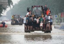 洪災再重創中國經濟 專家憂北京恐攻台轉移焦點 中國華北地區洪災嚴重。圖為河北省涿州市災民搭車涉水。圖/取自中新社