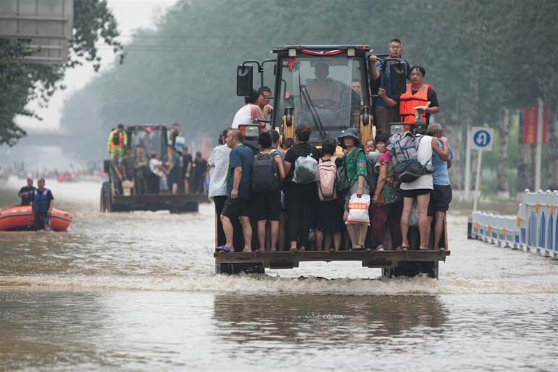 中國華北地區洪災嚴重。圖為河北省涿州市災民搭車涉水。圖/取自中新社