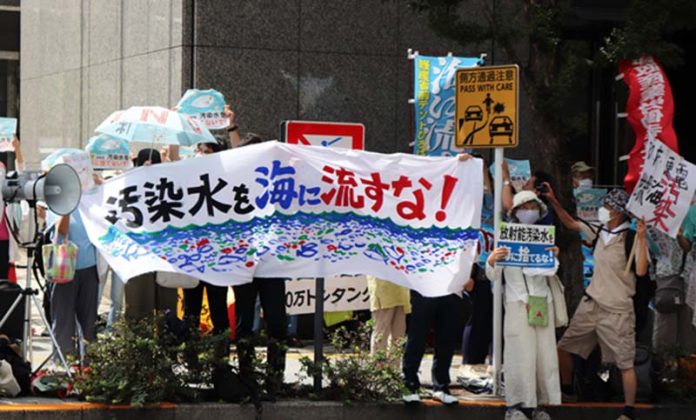 上月核污水排放當天，日本民眾手持「不許將污染水排入大海」等標語，在東京電力公司總部前抗議。圖／取自新華社