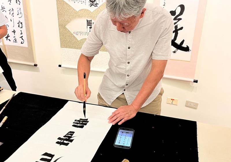 書畫家黃顯輝現場書寫揮毫示範。圖／中國科大藝文中心提供