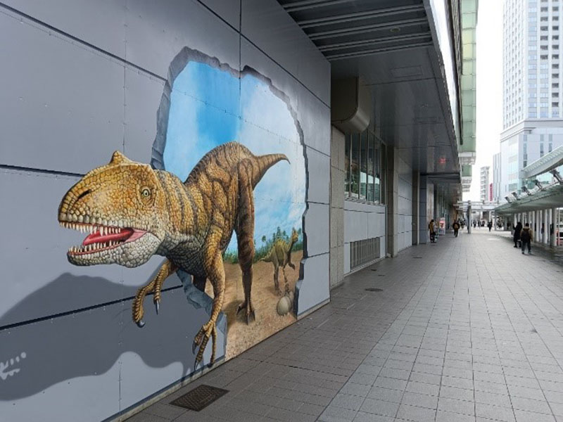 站體外牆繪有擬真的3D恐龍圖樣，牠們的行為正好是「撞破牆壁」。
