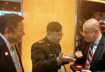 國戰會論壇/長城與橄欖枝?解讀共軍擾台降溫的信號(蔡裕明) 何雷(中)向美方代表團團長、美國國防部副助理國防部長蔡斯(右)贈送中國人民解放軍軍事科學院的徽章。