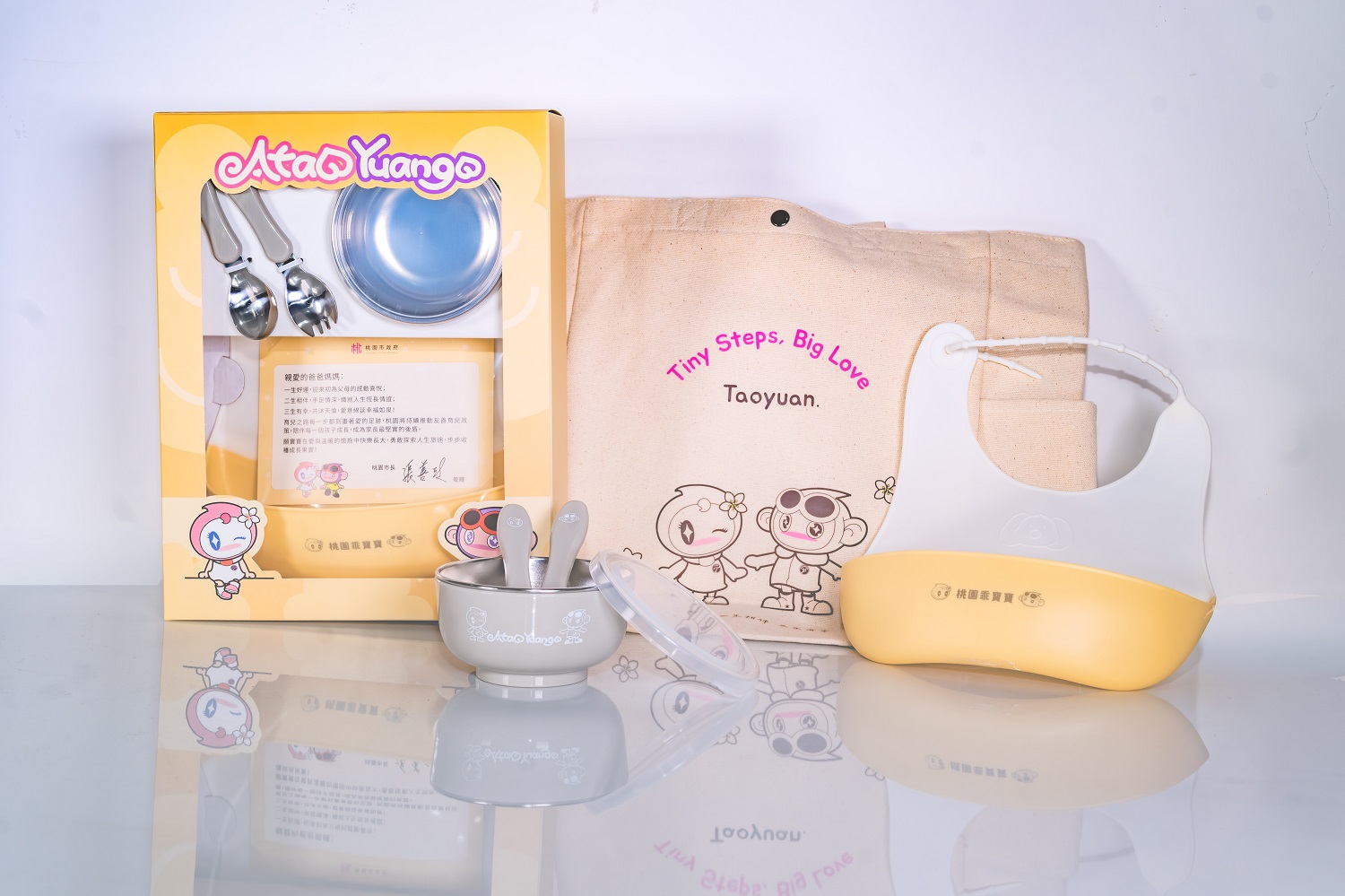 以桃園吉祥物宇宙版ㄚ桃園哥為設計主題的「桃園乖寶包」專屬禮袋，內含MIT製造的圍兜兜、餐具組與提袋，兼具實用性與城市識別度。
